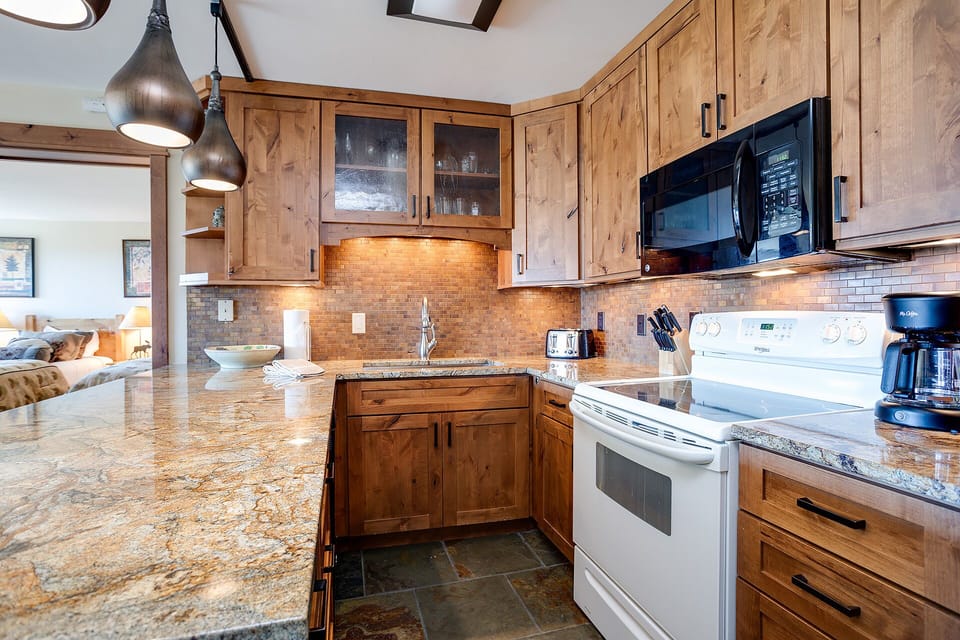 Your gourmet kitchen awaits with rich wood cabinets, granite countertops, and modern appliances for memorable meals together.