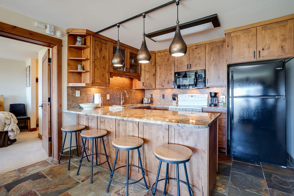 Your gourmet kitchen awaits with warm wood cabinetry, granite counters, and stylish pendant lighting for memorable meal preparations.