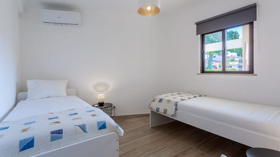 Two comfortable single beds invite restful sleep after a day of exploration, with a cozy bedside lamp for evening reading.
#Bedroom #Comfort #LovelyStay