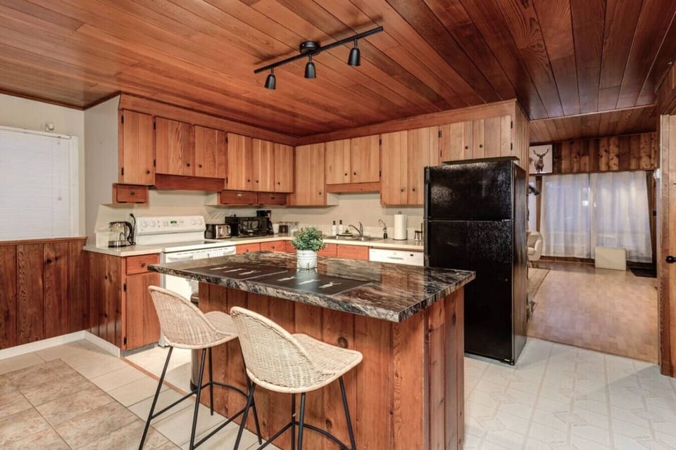 Start your mornings in this warm and inviting kitchen where the rich wood accents and spacious island create the perfect space to brew coffee, share meals, and plan your day’s adventures in total comfort.