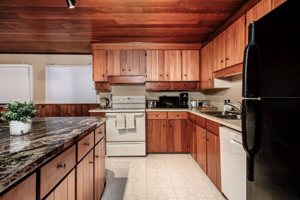 Whip up delicious meals in this warm and inviting kitchen where rustic wood tones meet modern convenience. Fully equipped with everything you need, it is the perfect place to brew your morning coffee, prepare family feasts, or share late night snacks afte