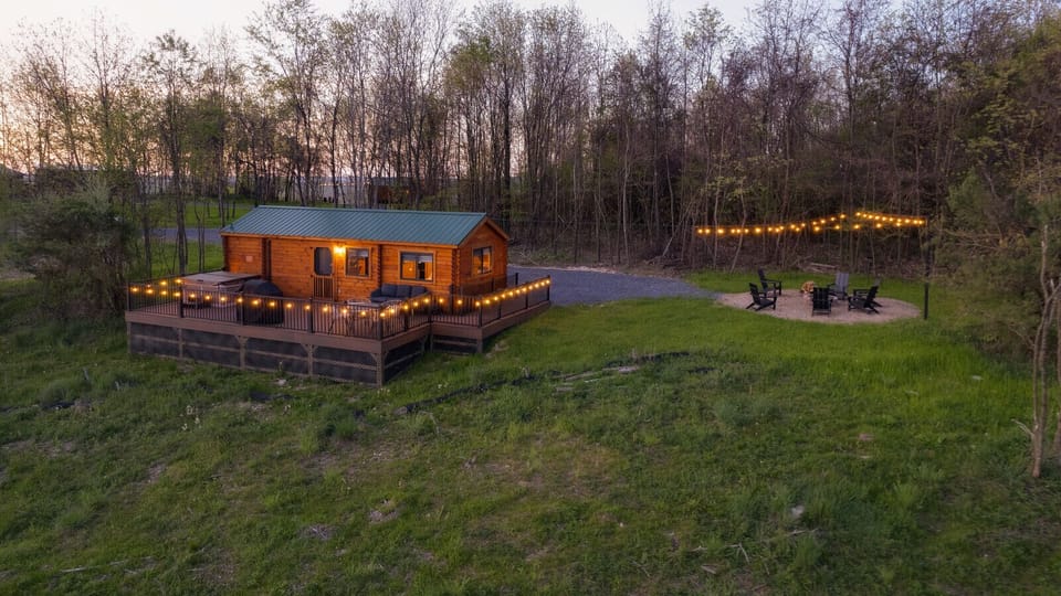 Cozy cabin with string lights, a large deck, and fire pit area