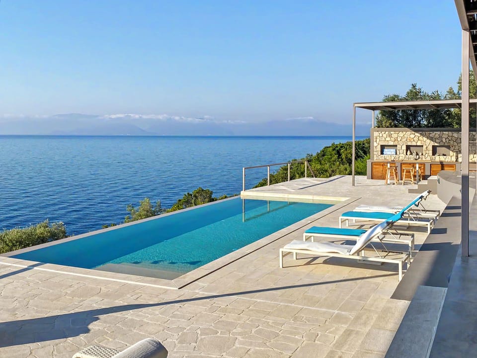 Infinity pool and loungers with panoramic Ionian Sea views await your arrival.