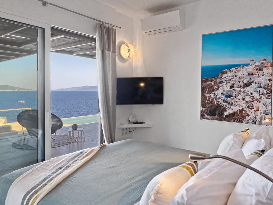 Peaceful bedroom opens to a private balcony with calming sea vista beyond.