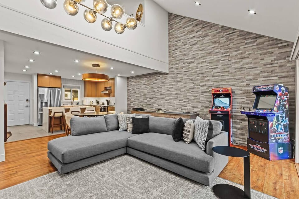Open-concept living at its best! Relax on the massive sectional or play NBA Jam & NFL Blitz in the game area. Seamlessly connects the fully equipped kitchen, dining, and vaulted living room for the ultimate Pocono family stay.