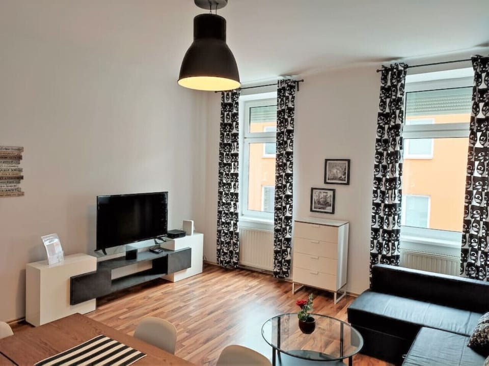 Step into the living room, where Arbio Designers` expertise shines through, creating a warm and inviting atmosphere, perfect for socializing or watching TV.