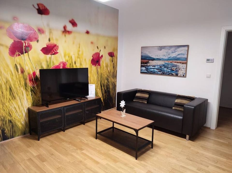 Step into the living room, where Arbio Designers` expertise shines through, creating a warm and inviting atmosphere, perfect for socializing or watching TV.