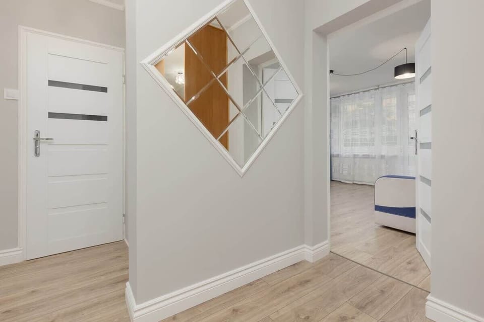 A corner of the hallway featuring unique decorative mirrors and clean, bright design elements.
