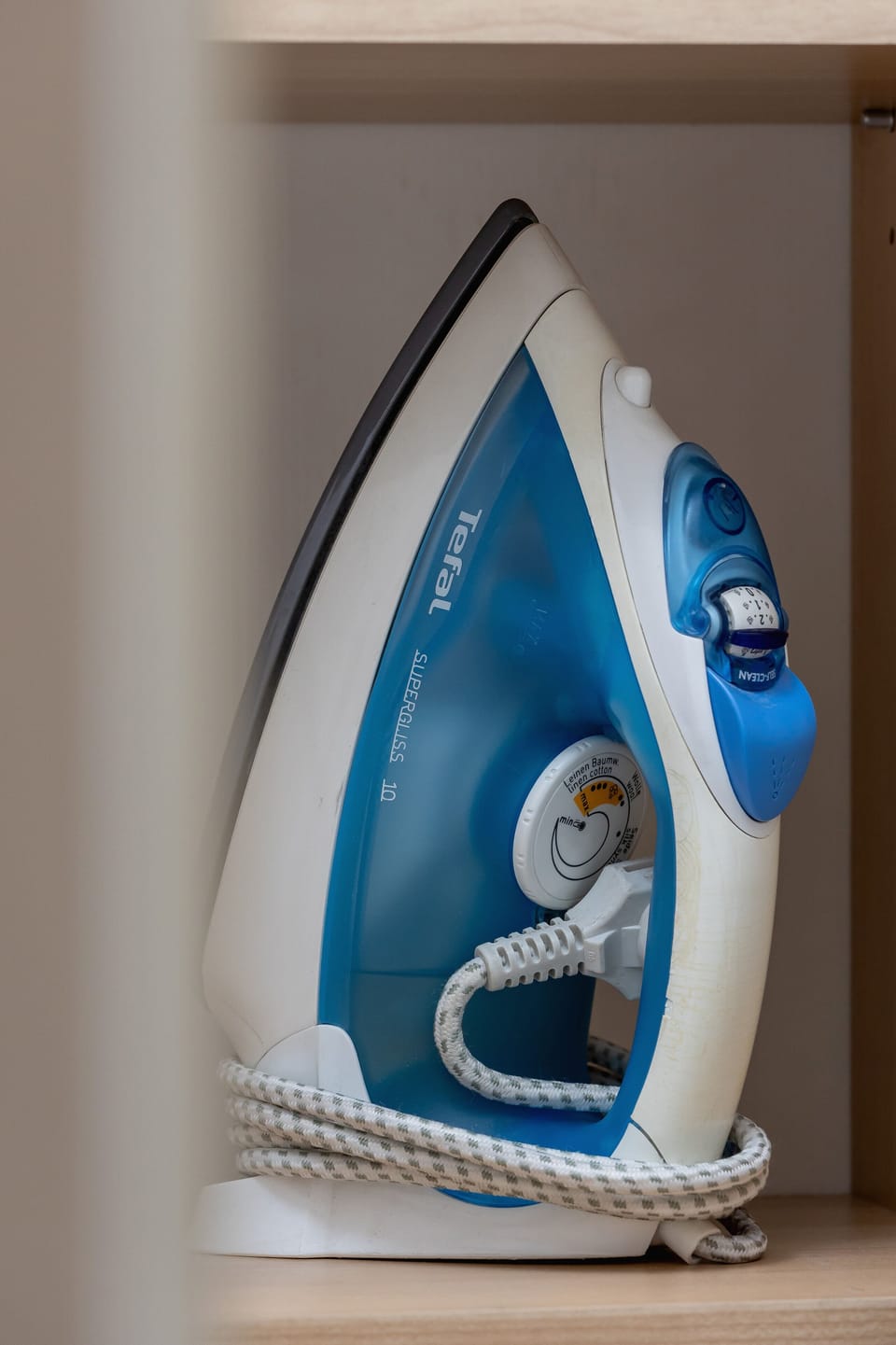 A neatly stored iron, placed on a shelf, offering convenience for household tasks.
