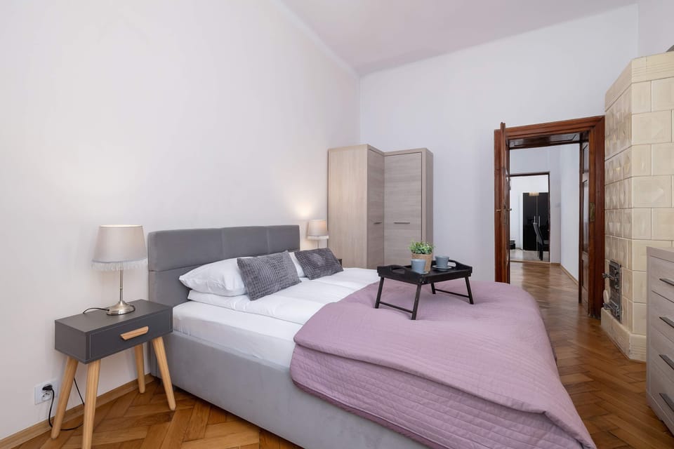 Another angle of the bedroom, emphasizing the soft bedding, bedside tables, and decorative elements.
