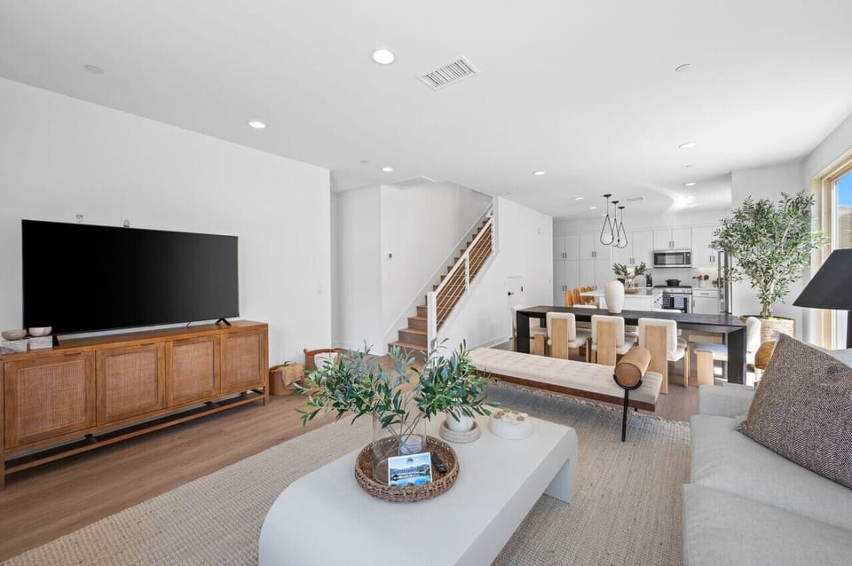 Spacious living area w/ TV, cozy seating & open layout flowing into the kitchen