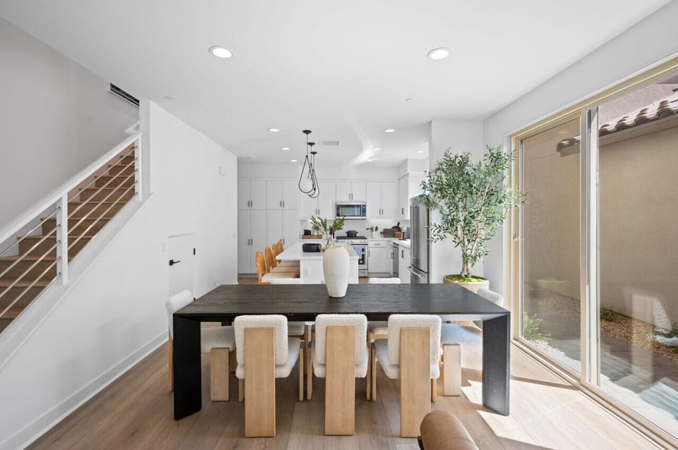 Dining area w/ table seating & sliding doors opening to a bright outdoor patio