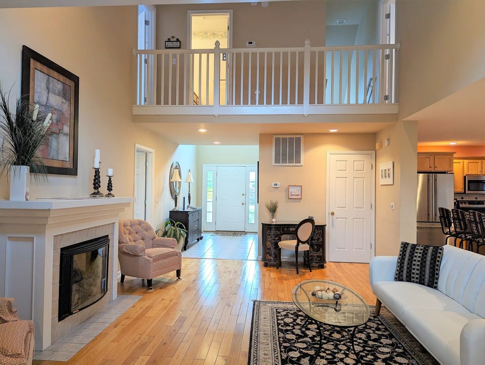 109 Soft Shell Cove - Great Room with Overlooking Loft - A view of the main living area showcasing the high ceilings, a white fireplace mantel, and a second-story wooden loft railing that overlooks the space.