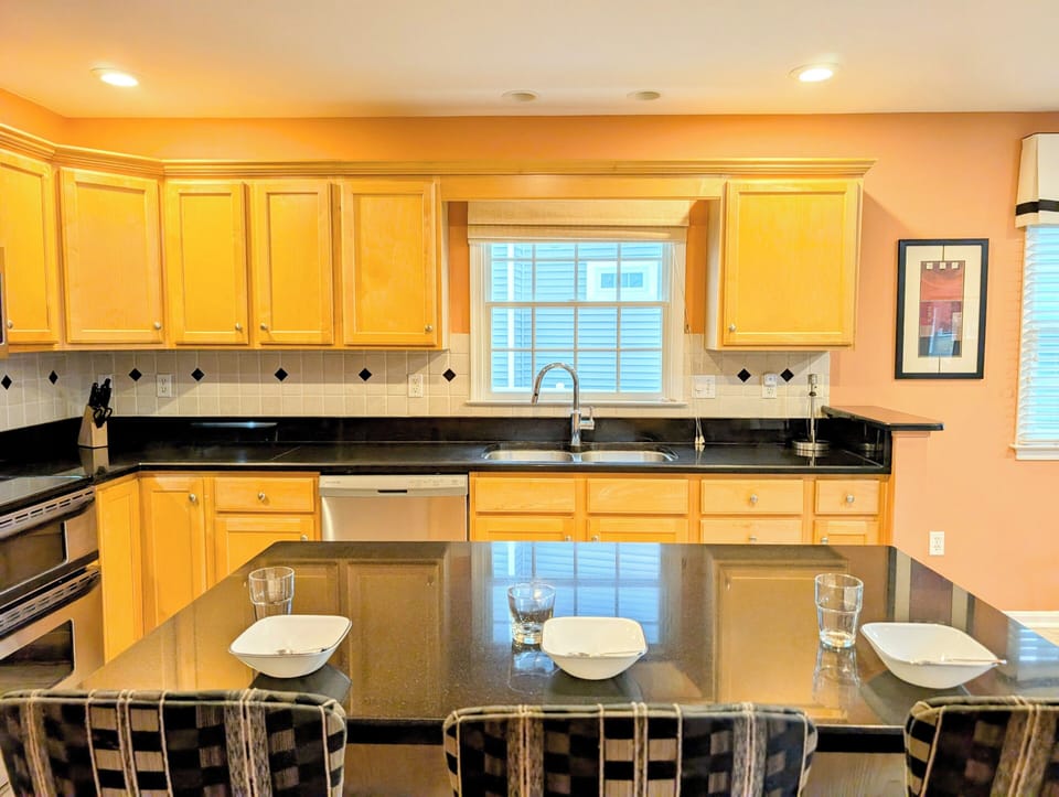 109 Soft Shell Cove - Functional Kitchen Workspace - A close-up view of the kitchen's extensive counter space and cabinetry, highlighting the recessed lighting and large window overlooking the exterior.