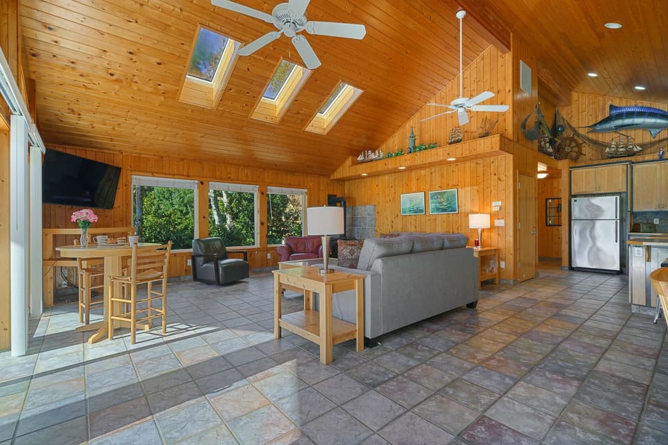 Upstairs open living space with Cable TV, gas fireplace, 2 sleeper sofas, fully stocked kitchen, and dining area. Access to front deck with BBQ.