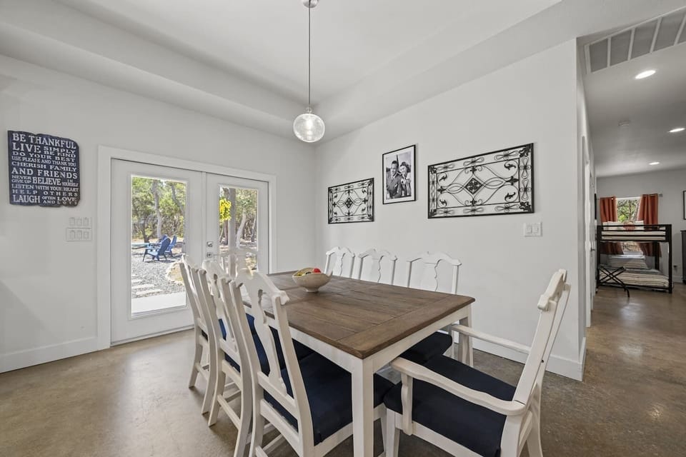 Bright and spacious dining room with seating for eight, modern décor, and direct patio access.