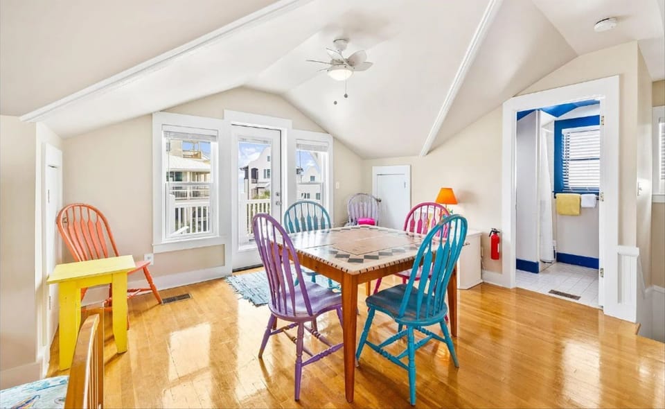 Gather around this charming dining table with colorful chairs where your family meals become memorable moments in this bright, airy space.