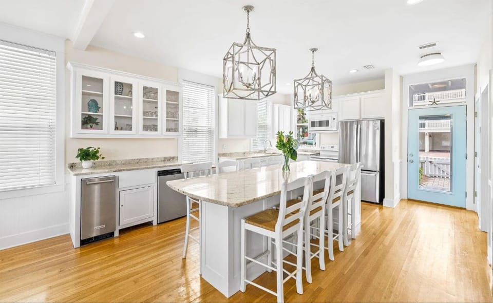 Step into this bright, elegant kitchen where you'll love cooking together around the spacious island with gleaming countertops and modern appliances.
