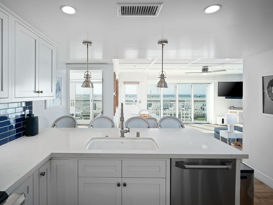 This fully equipped open-plan kitchen boasts a modern design, sleek countertops, and a stylish bar with stools for casual dining.