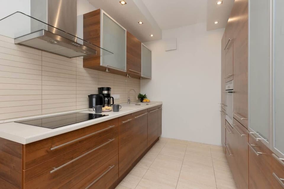 A modern kitchen featuring dark wooden cabinets, light countertops, and sleek appliances, blending functionality with a contemporary design.