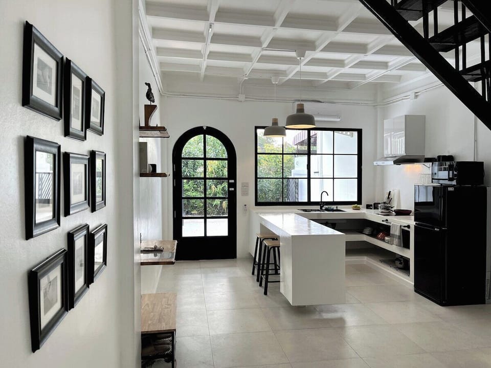 Bright and spacious kitchen with a sleek island, modern appliances, and plenty of natural light. The charming arched door and elegant wall decor add character, making it a perfect spot to cook, dine, or enjoy a morning coffee.