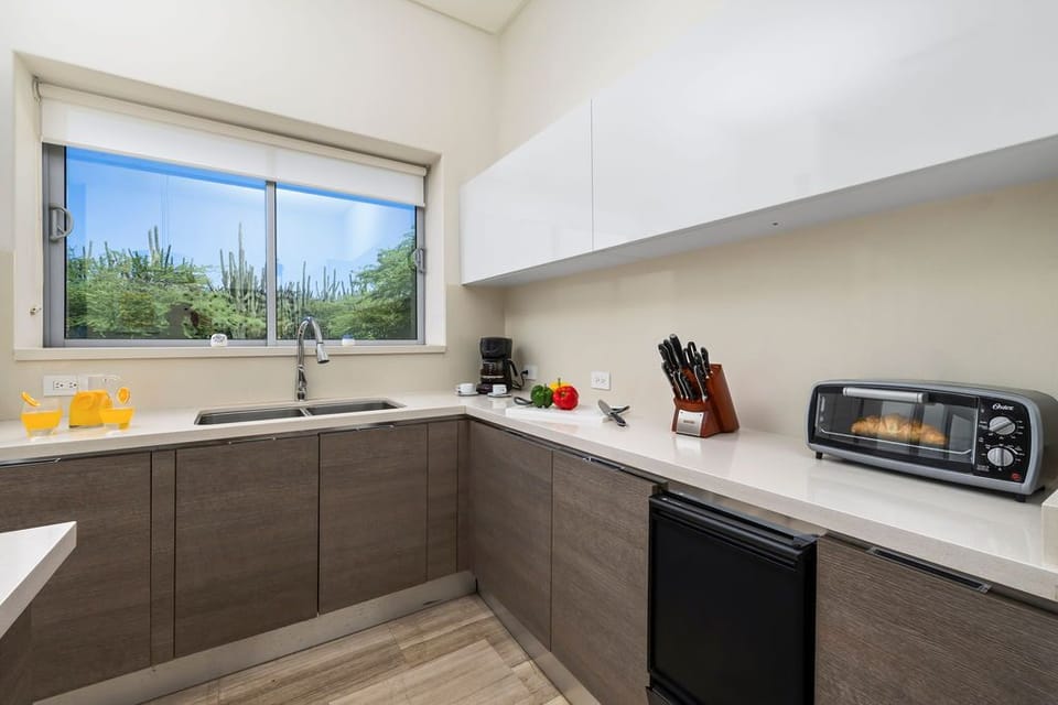 Step into the heart of the villa, where the open design seamlessly integrates the living room, dining space, and fully equipped kitchen.