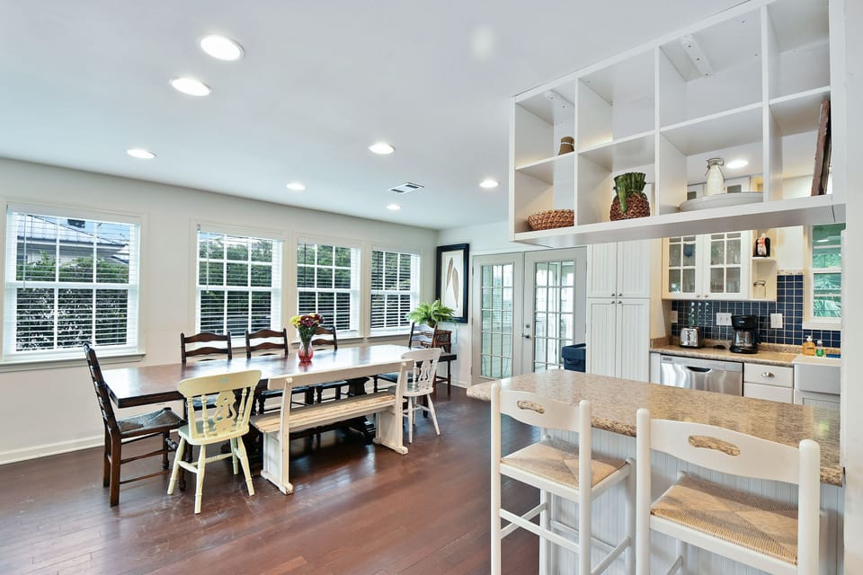 Kitchen and Dining Area with Bar Seating - Kitchen, bar stools, open shelving, dining table, and living room connection at Jack's Place.