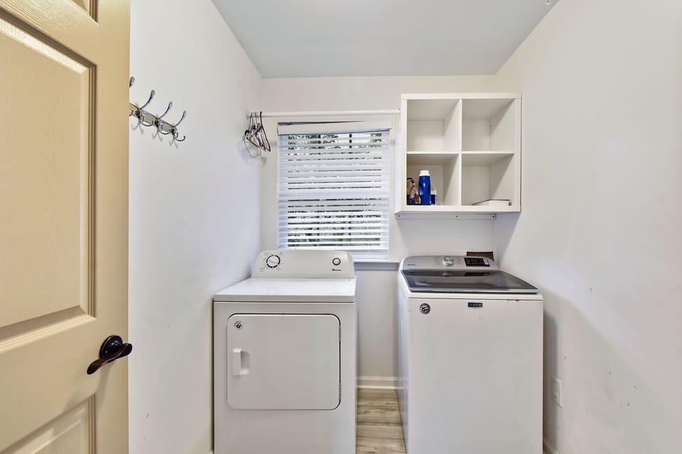 Laundry Room with Washer and Dryer - Full-size washer and dryer, shelf storage, wall hooks, and hallway access.