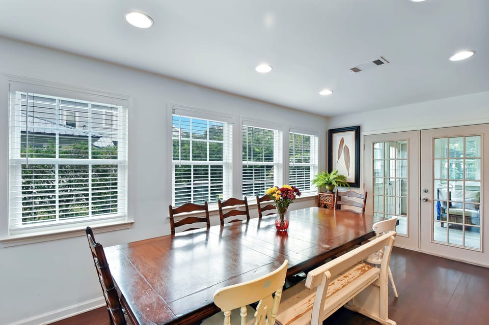 Dining Table and French Doors - Dining table sits beside wide windows and French doors, close to the kitchen and living room.