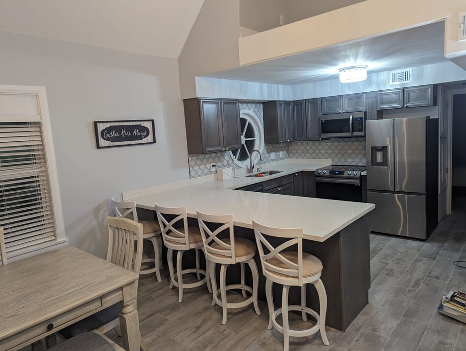 Dining/Kitchen view with chairs to seat 10 people (table + bar)