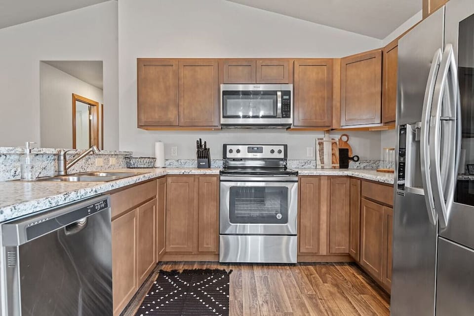 Well-equipped kitchen featuring an oven, stove, refrigerator, and dishwasher for your cooking convenience.
