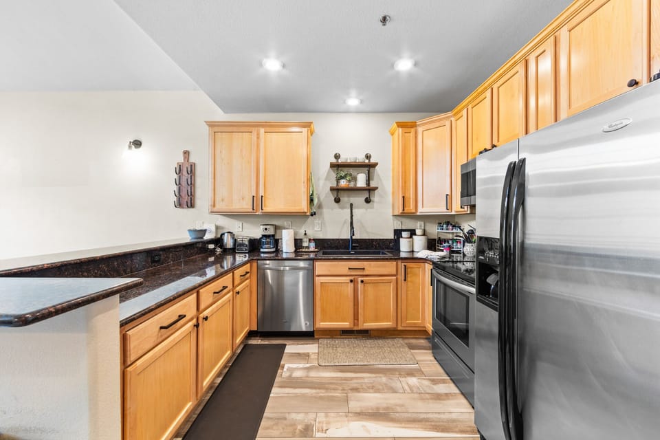 Your fully equipped kitchen features warm wood cabinets, granite counters, and stainless steel appliances—perfect for home-cooked meals.