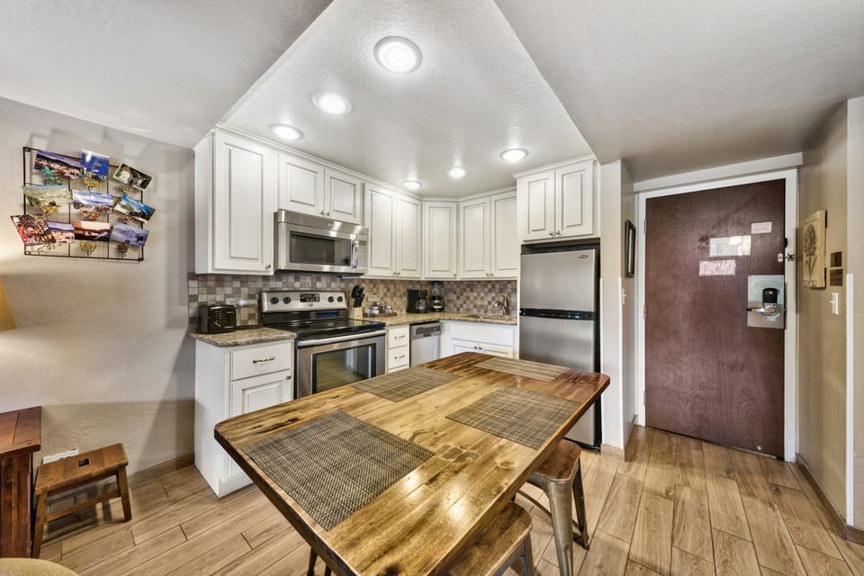 Whip up your favorite meals in this fully equipped kitchen featuring granite counters, stainless appliances, and rustic dining table.