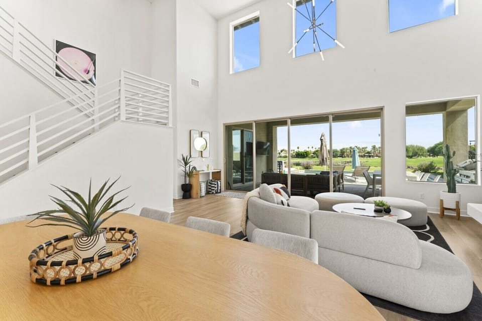 Open-concept layout w/ cozy seating, loft above & seamless indoor-outdoor flow.
