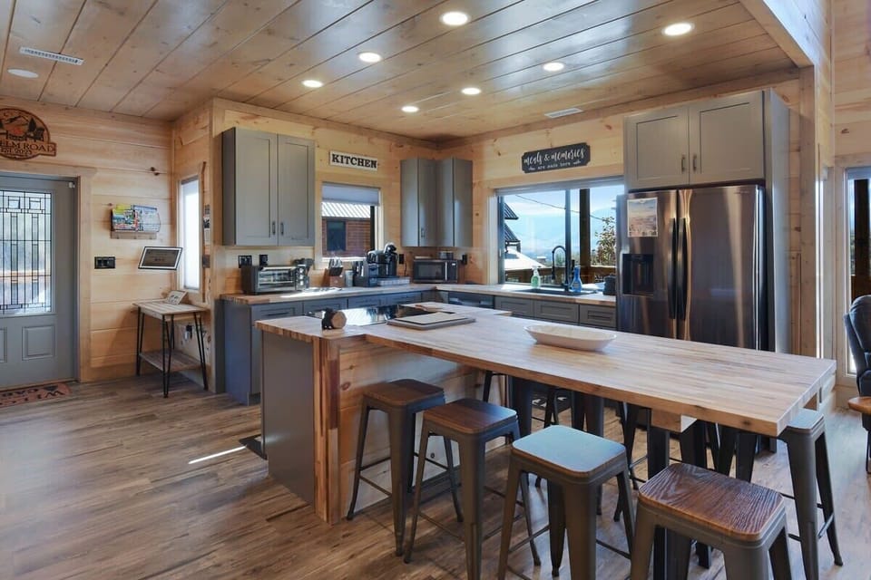 Modern kitchen with a large wooden island and mountain views through the window