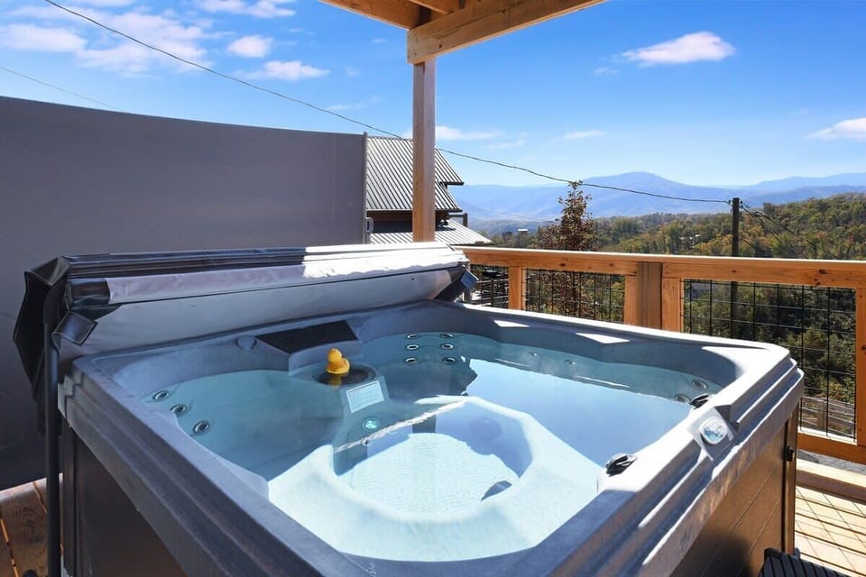 Outdoor hot tub with mountain views on a wooden deck