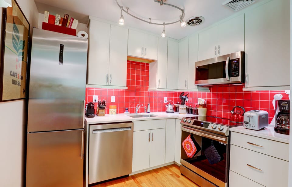 Fully Equipped Kitchen with Appliances and Tomato Red Tiled Backsplash