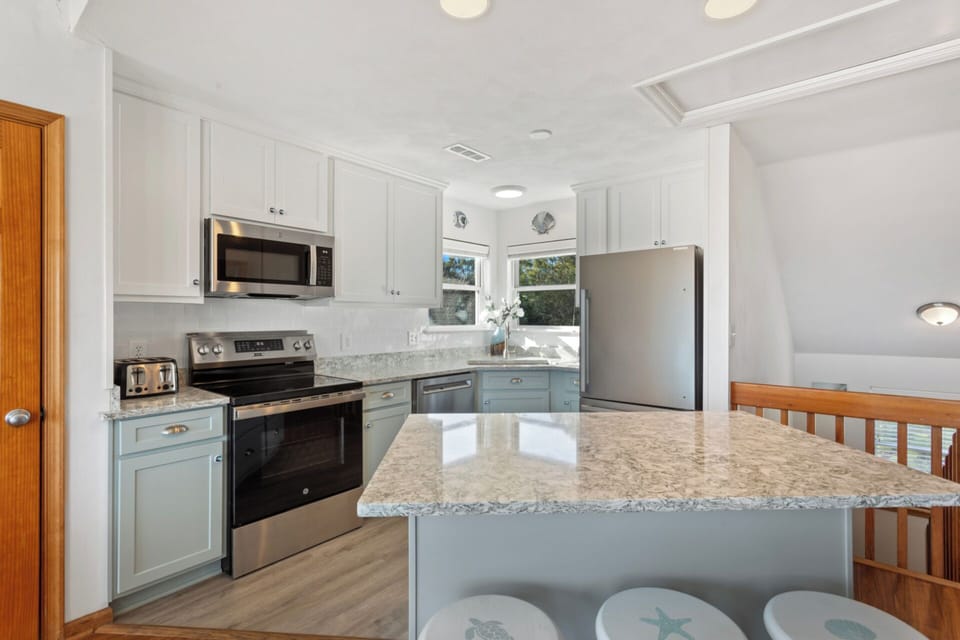 The Open-Concept Kitchen with modern appliances and refrigerator with ice maker is perfect for whipping up a delicious meal that will impress the whole family.