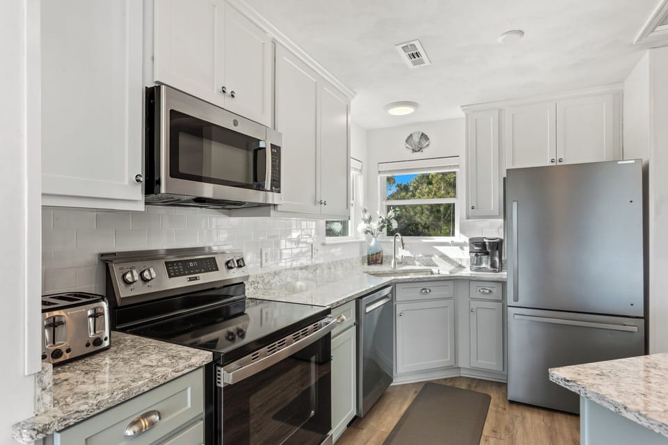 The Open-Concept Kitchen with modern appliances and refrigerator with ice maker is perfect for whipping up a delicious meal that will impress the whole family.