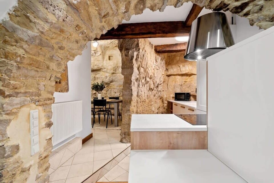 Spacious kitchen area framed by stunning stone arches, combining rustic charm with sleek modern finishes for a memorable cooking experience.