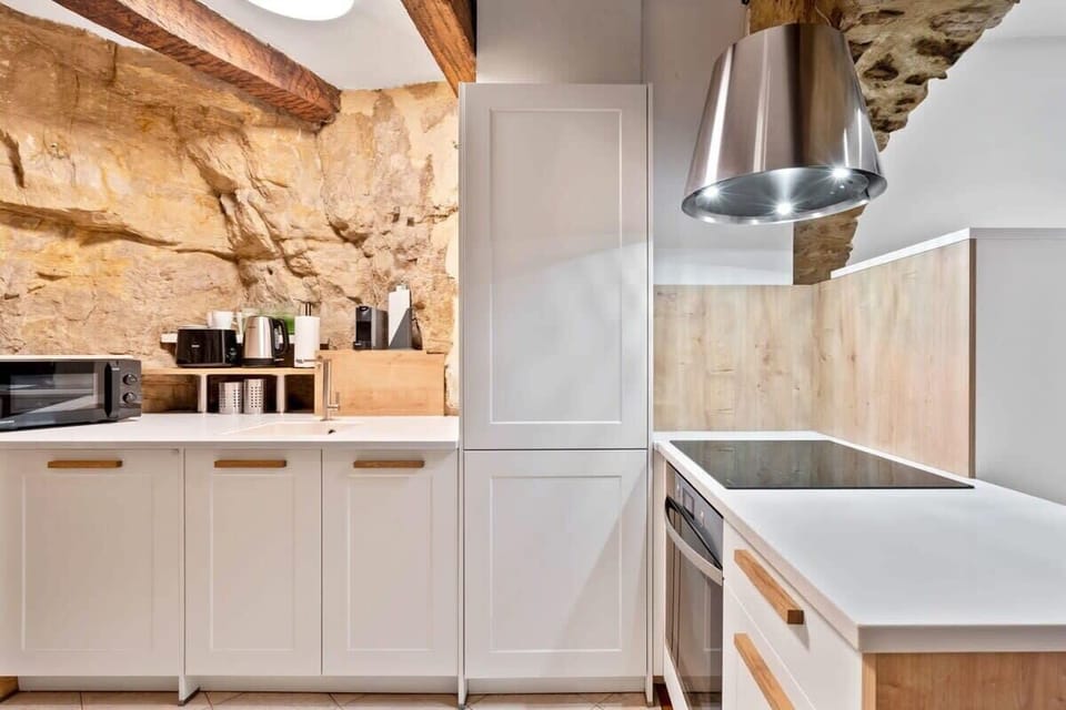 Fully equipped kitchen with high-end appliances, warm lighting, and natural stone accents that create a unique and inviting atmosphere.