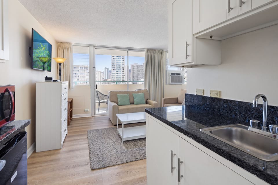 Step into your bright, airy studio where city views meet coastal comfort. Unwind on the cozy sofa, whip up meals in your sleek kitchenette, and step onto your private balcony to soak in the skyline.