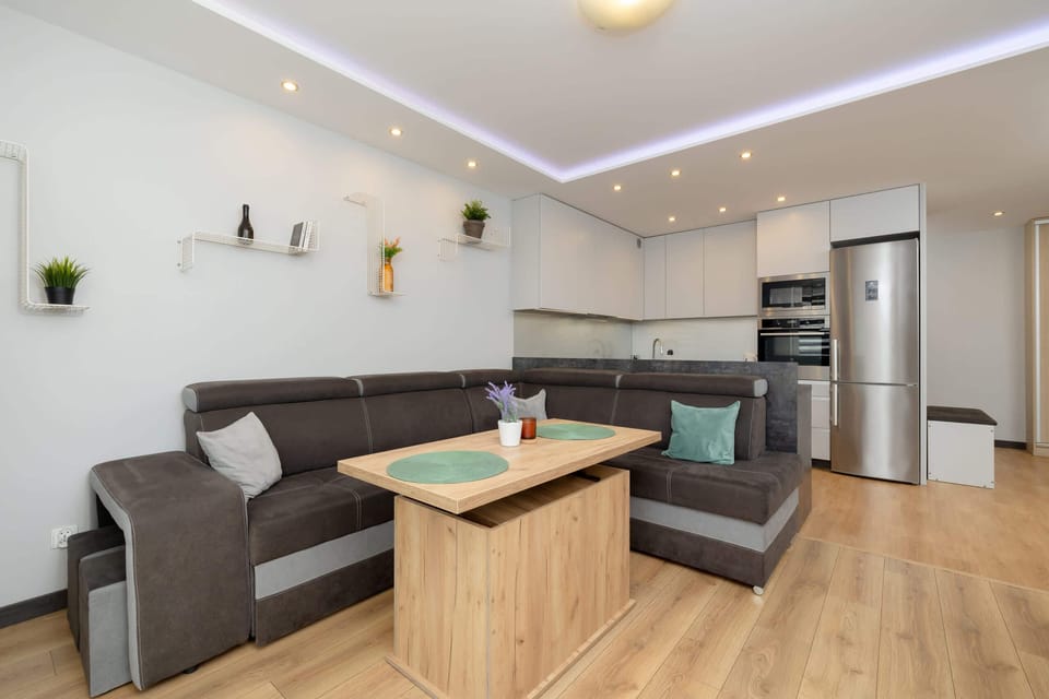 A living room with a large corner sofa in grey tones inviting you to relax.
