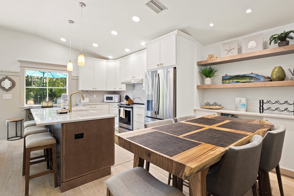 Your modern kitchen features gleaming white cabinets, granite counters, and a welcoming dining table where you'll share memorable meals together.