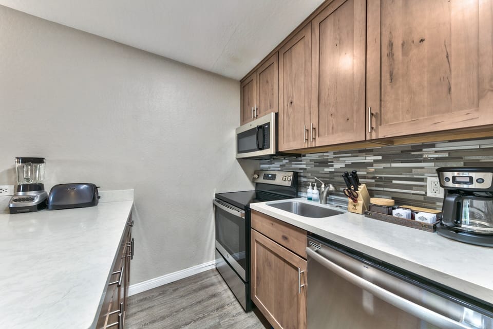 Your fully equipped kitchen features warm wood cabinetry and modern appliances, perfect for preparing home-cooked meals during your stay.