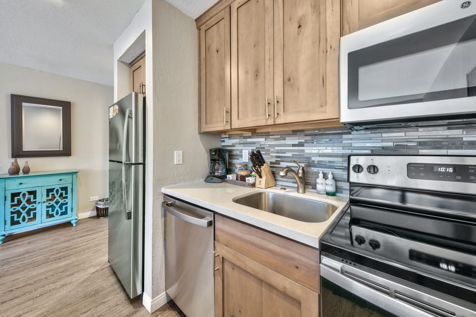 Your fully equipped kitchen features warm wood cabinets, stainless steel appliances, and a stylish backsplash for memorable meal prep.