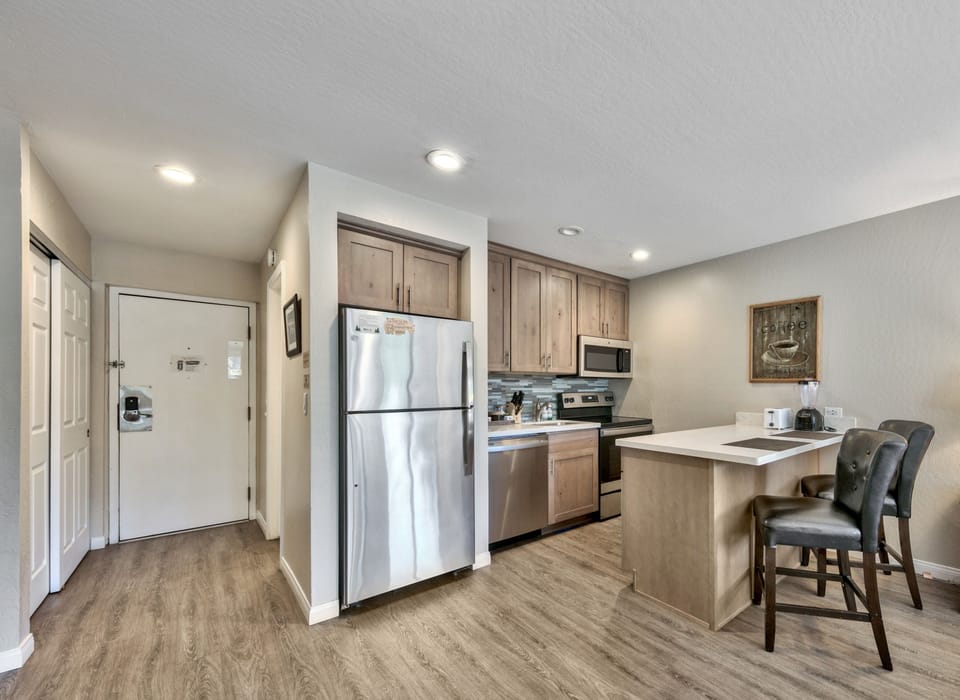 Your modern kitchen features stainless steel appliances, warm wood cabinetry, and a breakfast bar perfect for morning coffee.