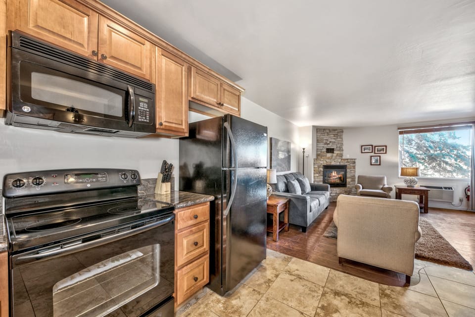 Step into your fully equipped kitchen where granite counters and stainless appliances make cooking effortless. Relax in the cozy living room with fireplace views.