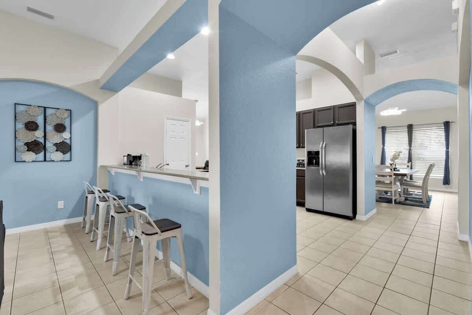 Transform your mornings with this inviting kitchen, boasting a charming bar with four stools, creating the perfect spot to relish a fresh brew of coffee.