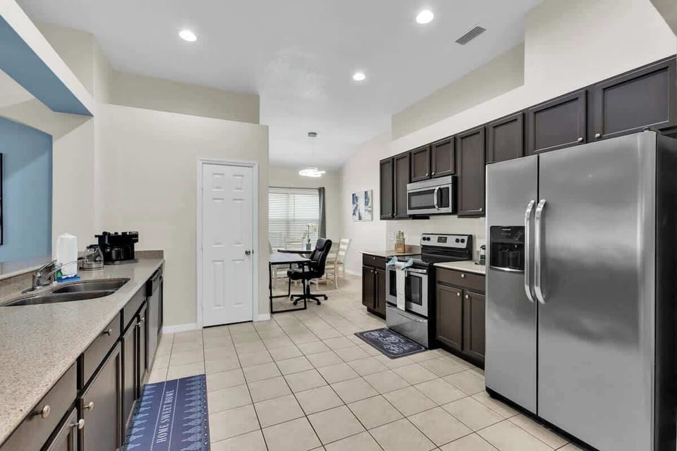 Effortlessly blend culinary delights and productivity in the kitchen, equipped with a full-size fridge boasting a water and ice dispenser, along with a cozy breakfast nook featuring a round table and a dedicated desk space.